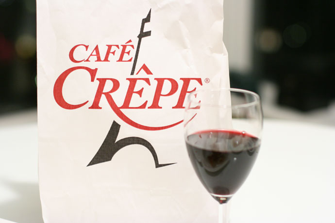 Cafe Crepe logo on a take-out bag with a glass of wine.