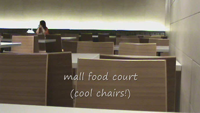 The food court has sleek, modern decor with cool lighting and neat chairs.